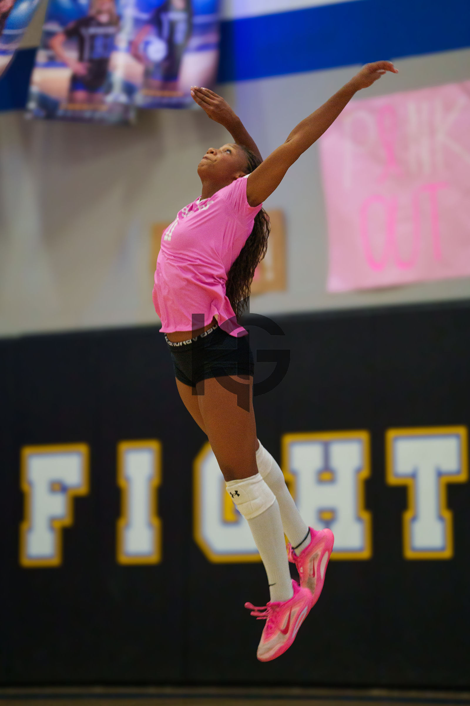 A volleyball hitter fully extended in the air at the net
